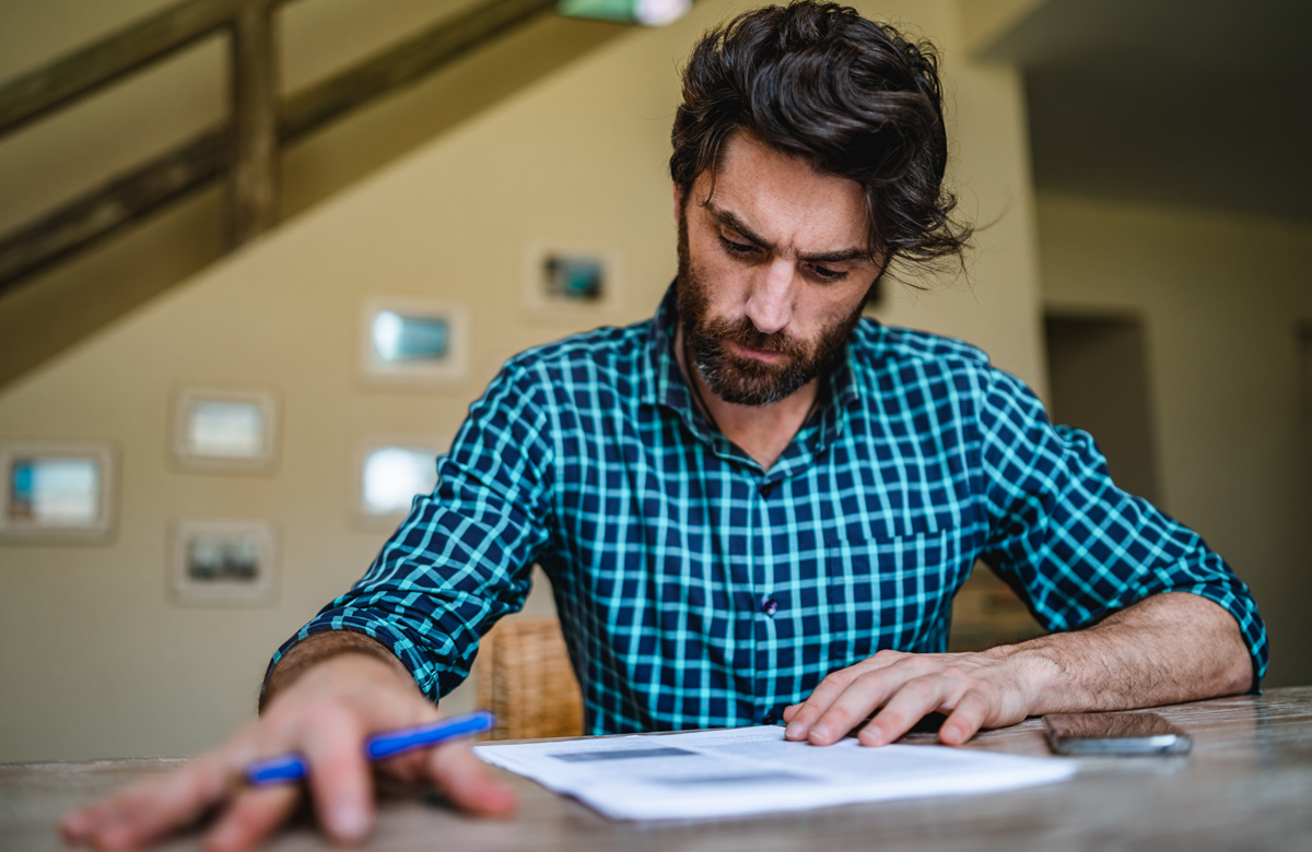 Man sitting at a desk signing paperwork