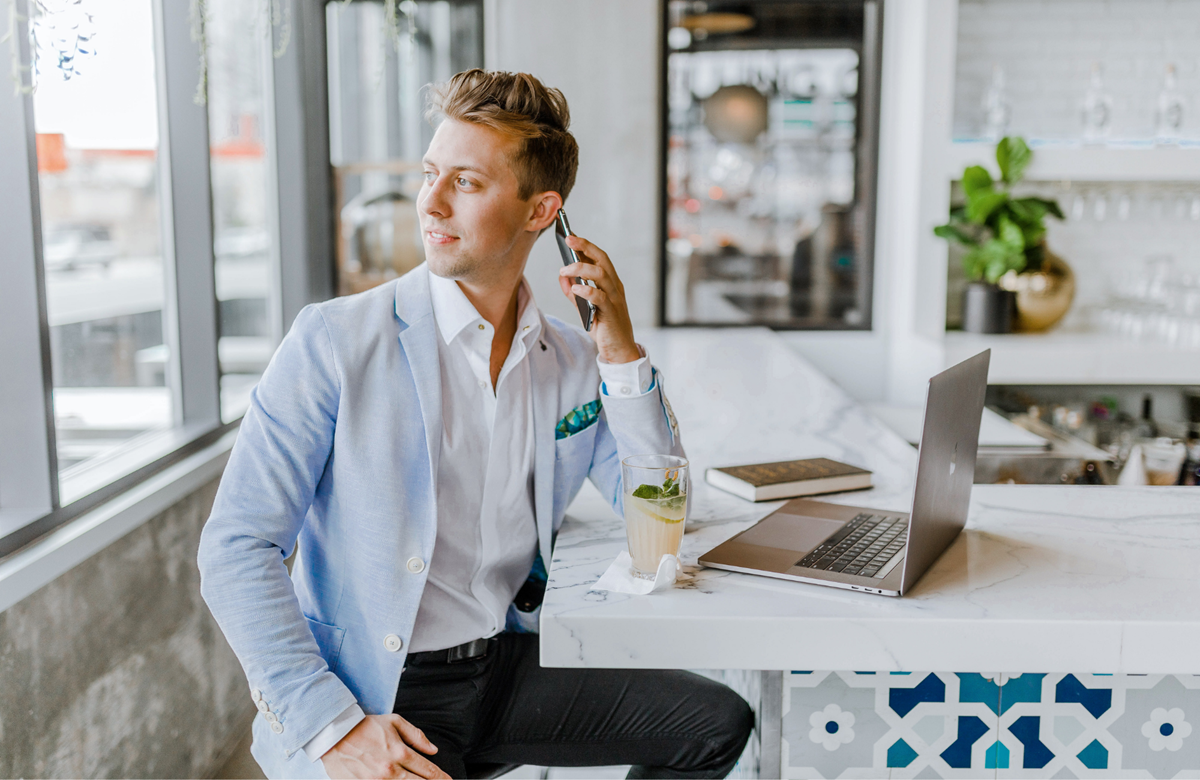 Male buyer's agent sitting at a desk on the phone to a client