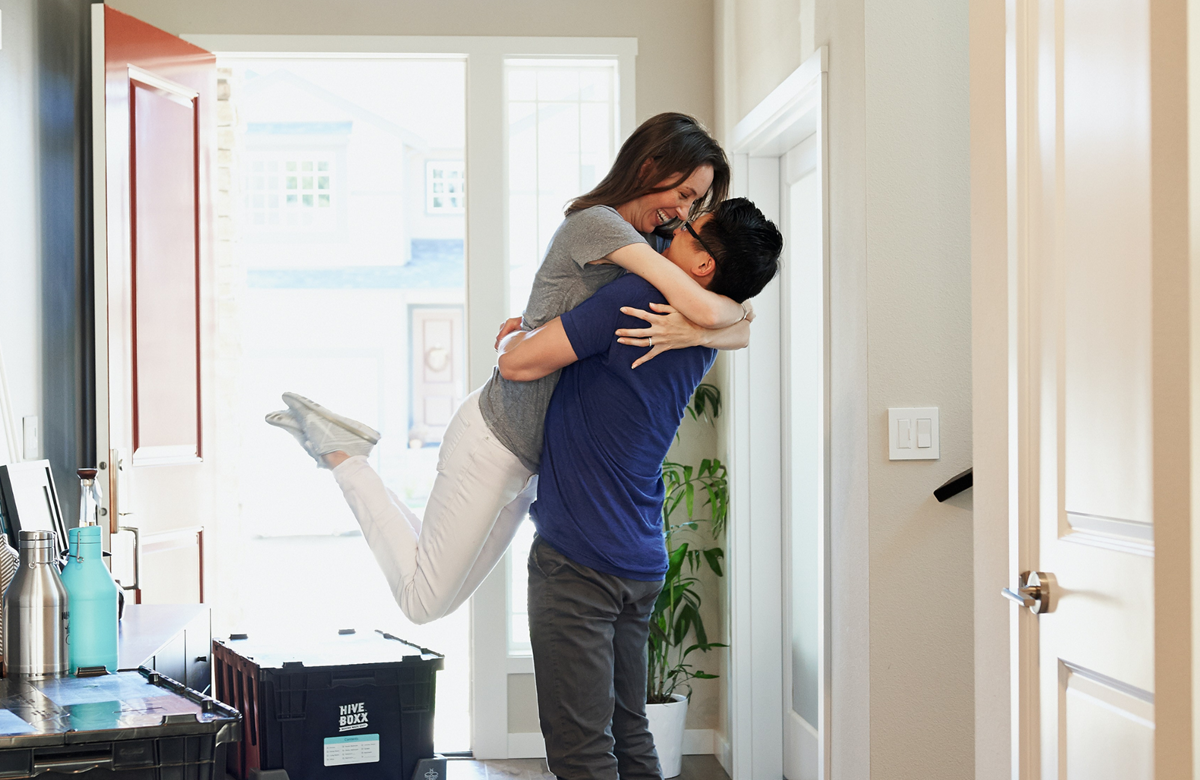 Couple hugging in hallway of their new home